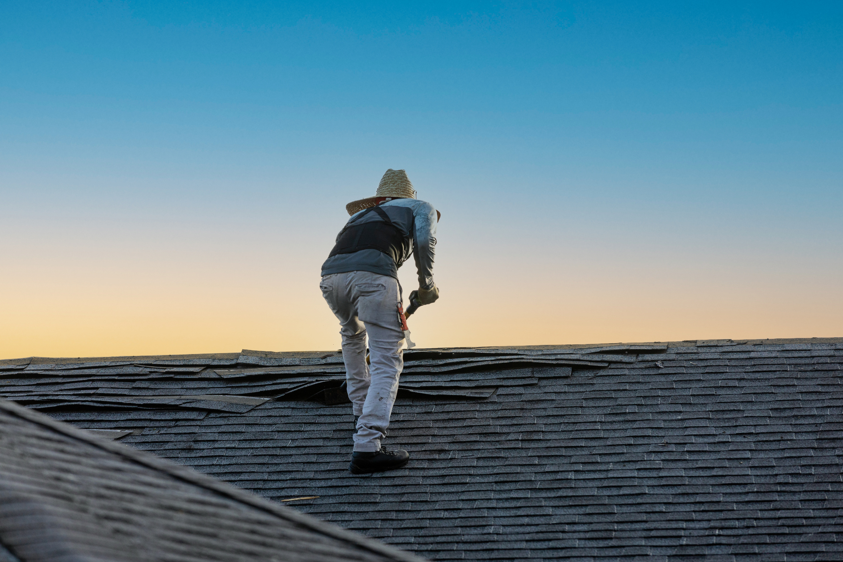 Person Removing Tiles of Roof